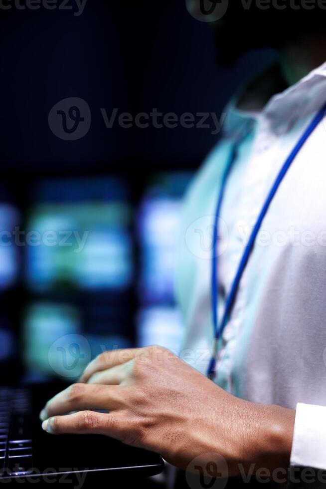 Extreme close up shot of IT programmer using laptop to run diagnostics on server hardware clusters. Data center enabling artificial intelligence to do complex calculations and process massive datasets photo