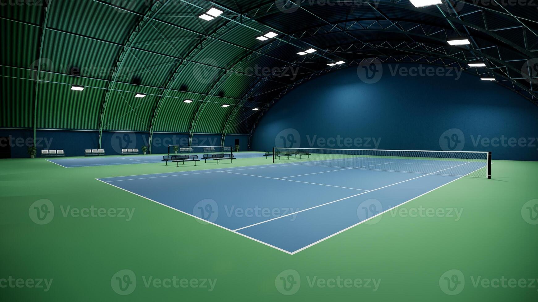 indoor tennis court adorned with a vibrant blue and green surface, equipped with lights and lined with spectator benches photo