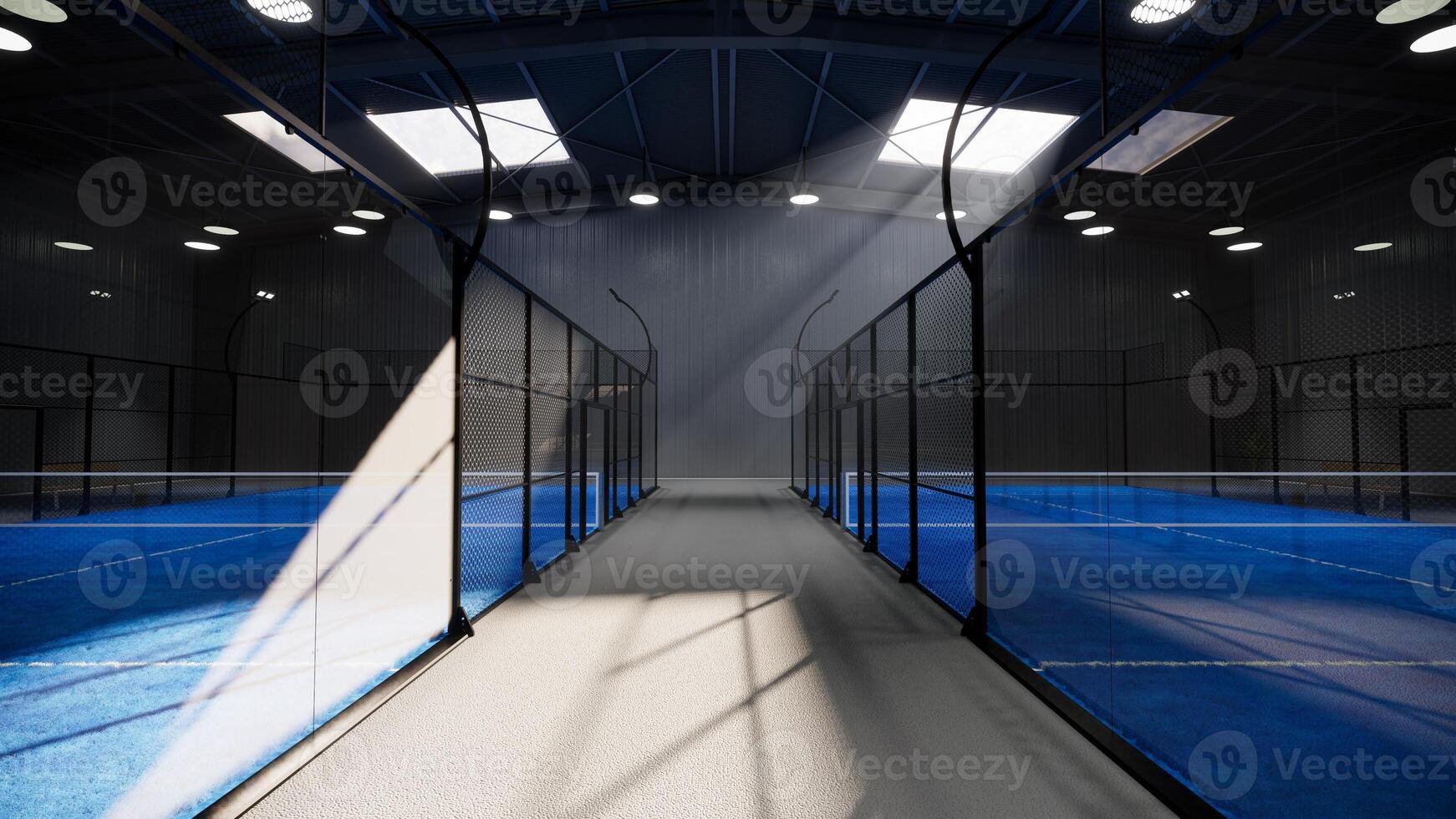 eye level view of unused blue padel tennis courts inside a warehouse building, located in the sports complex facility area. With lights turned on even though it is daytime photo