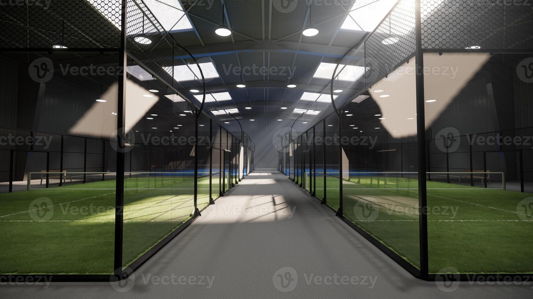 eye level view of unused green padel tennis courts inside a warehouse building, located in the sports complex facility area. With lights turned on even though it is daytime photo
