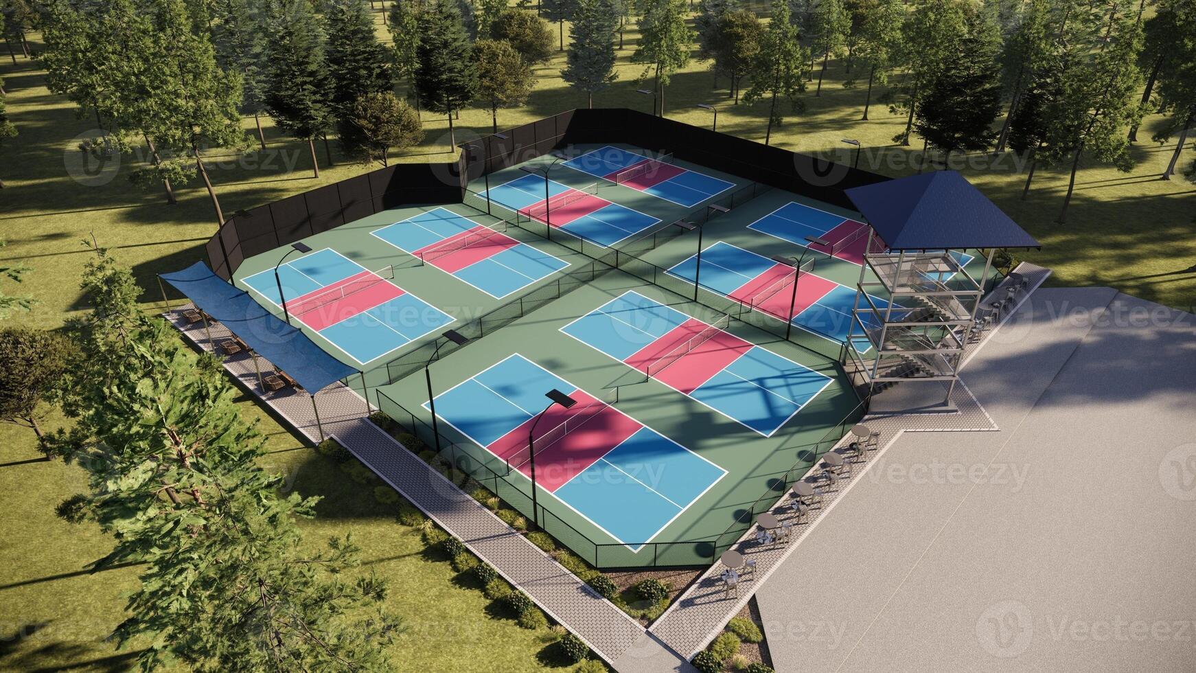 Aerial view of a pickleball tennis courts with a combination of red, blue, and green colors, equipped with lights, fencing, and seating in a rural area photo