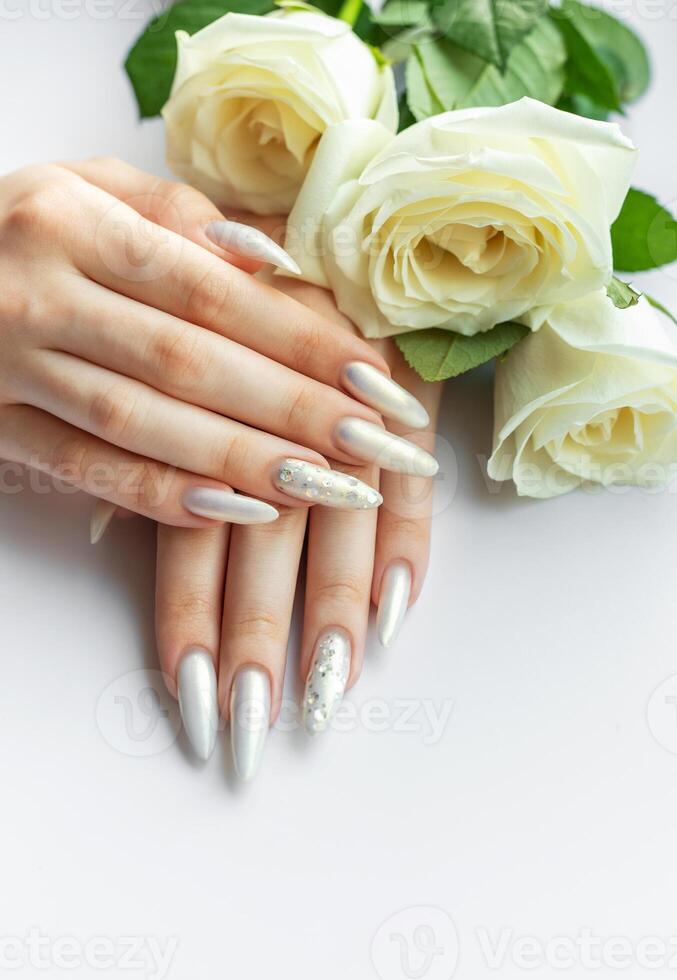 Female Hands with beautiful pearl manicure and white roses photo