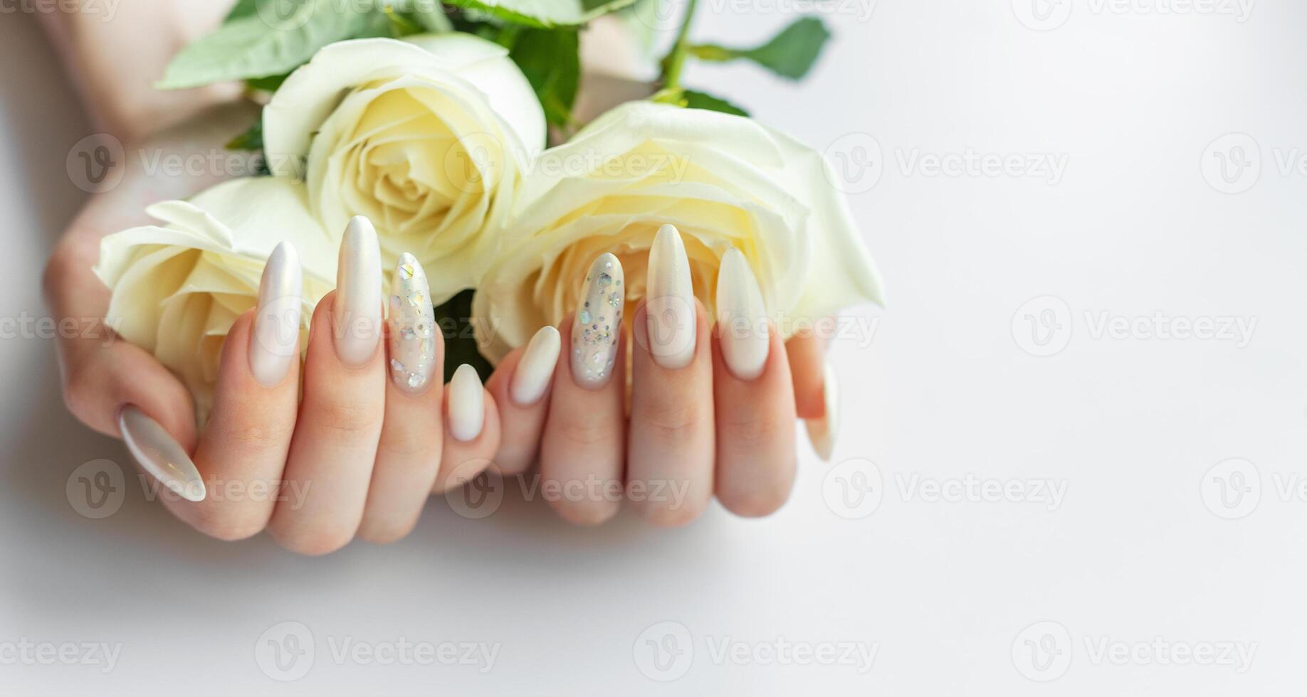 Female Hands with beautiful pearl manicure and white roses photo