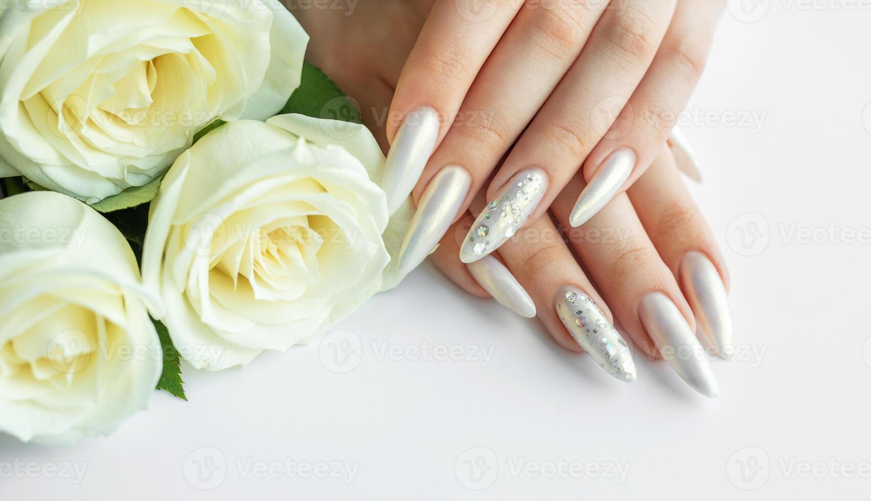 Female Hands on a white background with beautiful pearl manicure and white roses photo