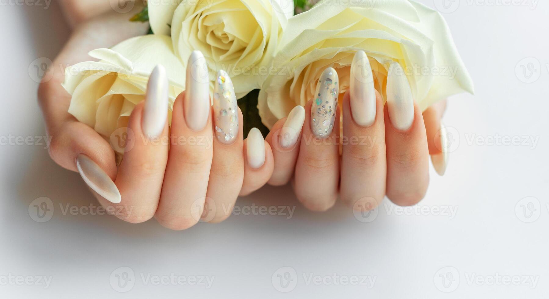 Female Hands on a white background with beautiful pearl manicure and white roses photo