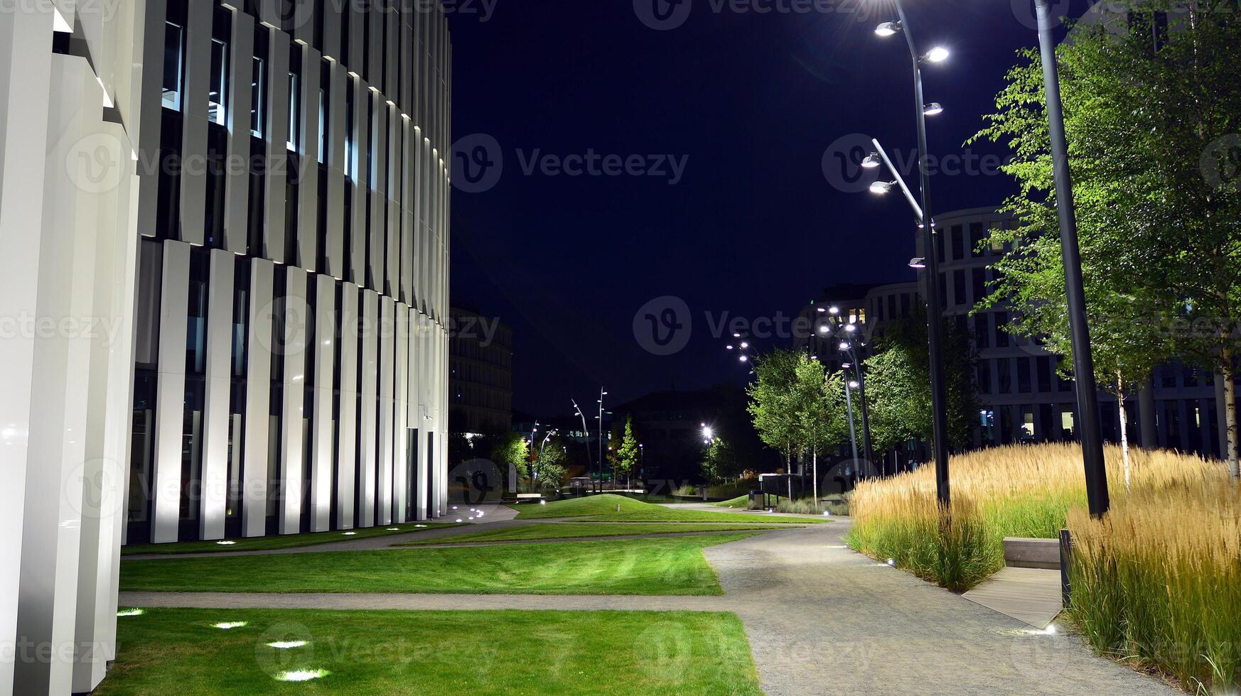 Pattern of office buildings windows illuminated at night. Glass architecture ,corporate building at night - business concept. photo