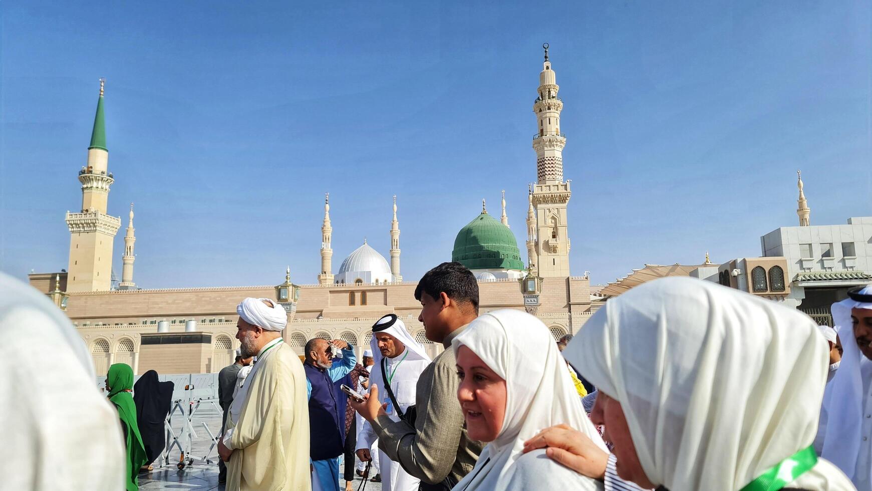 Medina, Saudi Arabia on March 1, 2024. Male and female Umrah pilgrims taking photos and walking in front of the tomb of the Prophet Muhammad at the Nabawi Mosque.