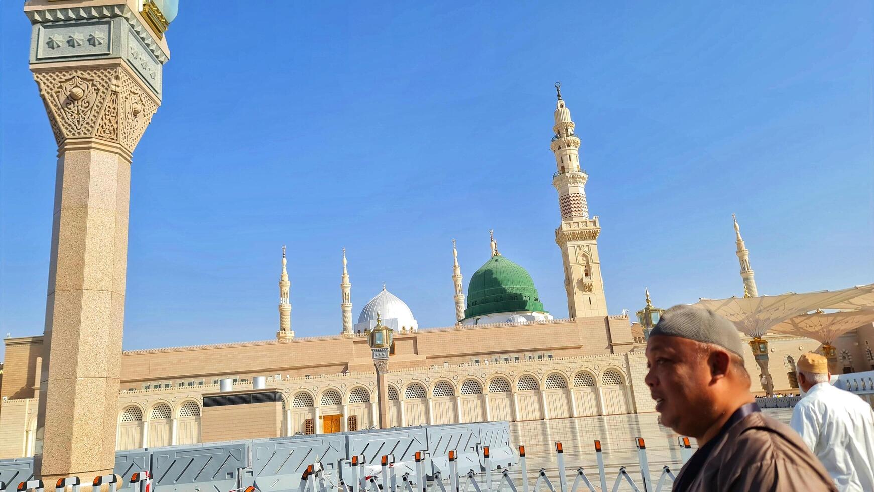 Medina, Saudi Arabia on March 1, 2024. Male and female Umrah pilgrims taking photos and walking in front of the tomb of the Prophet Muhammad at the Nabawi Mosque.