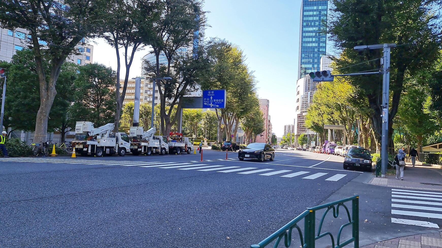Tokyo, Japan on October 1, 2023. Several people are walking on a zebra crossing, crossing the road on one of the streets in the Tokyo area, you can see signs pointing to Sanazaka and Shibuya. photo