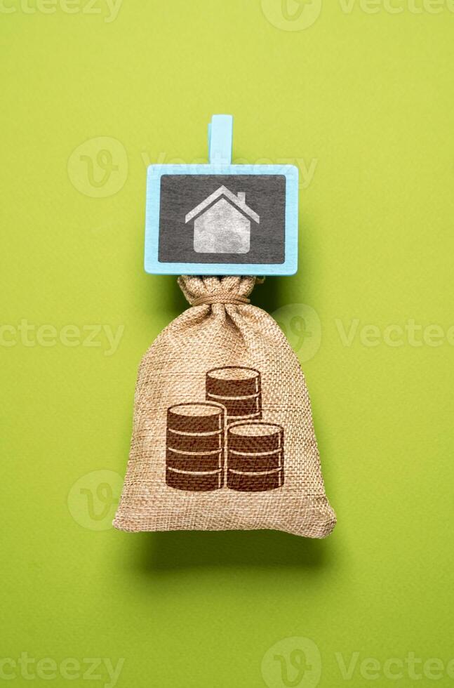 Money bag with savings for the house. Save to buy a house or an apartment. Collect money for dreams and intended purposes. Buy real estate now by taking out a mortgage. photo