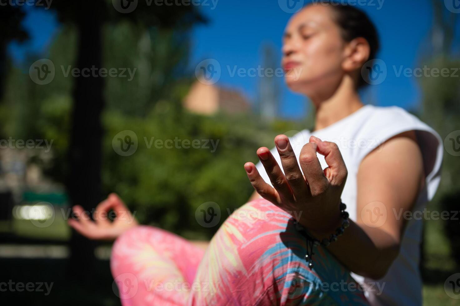 Woman practicing yoga meditation outdoors in a peaceful park photo