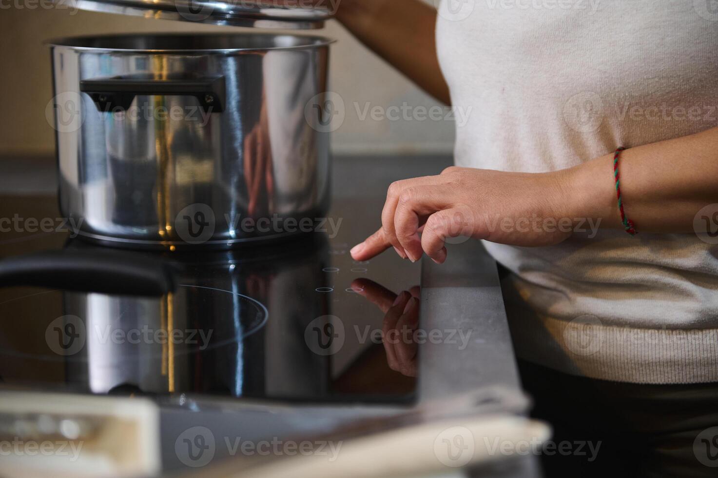 Cooking on induction stove with stainless steel pot photo