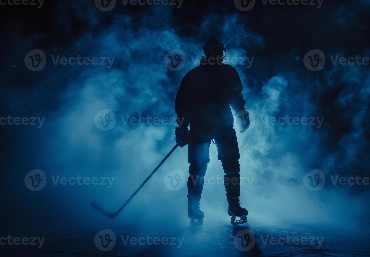 Silhouette of a hockey player in full gear standing on ice rink with dramatic blue and black lighting. photo