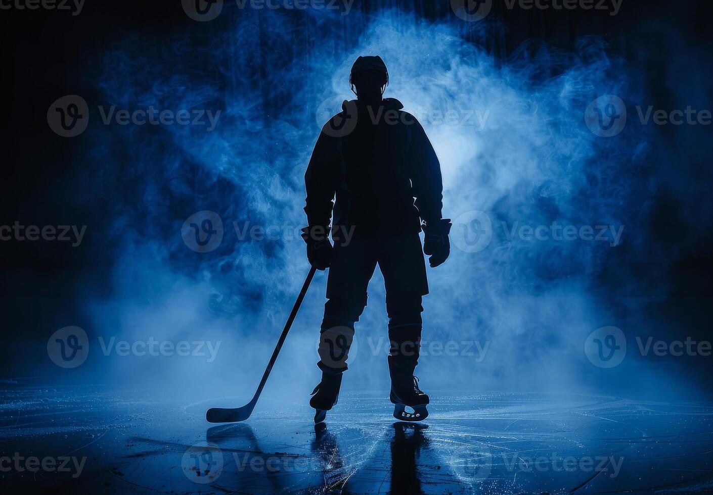 Silhouetted ice hockey player standing on the rink with a smoky blue background, creating a moody and dramatic atmosphere. photo