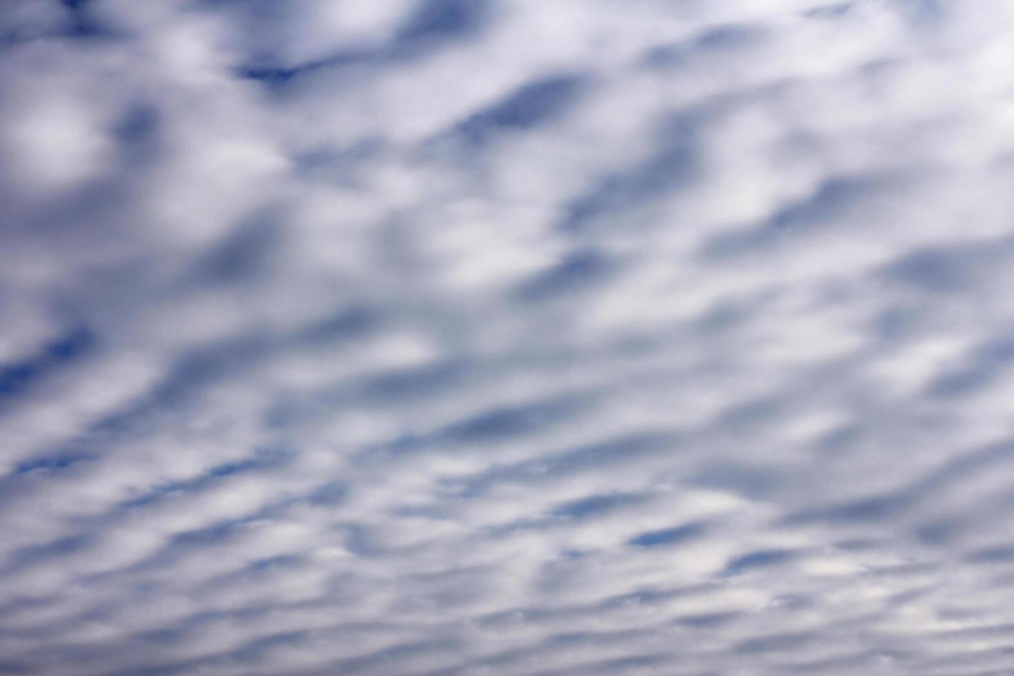 sky with layered cumulus clouds. blue background with unusual cloud texture photo