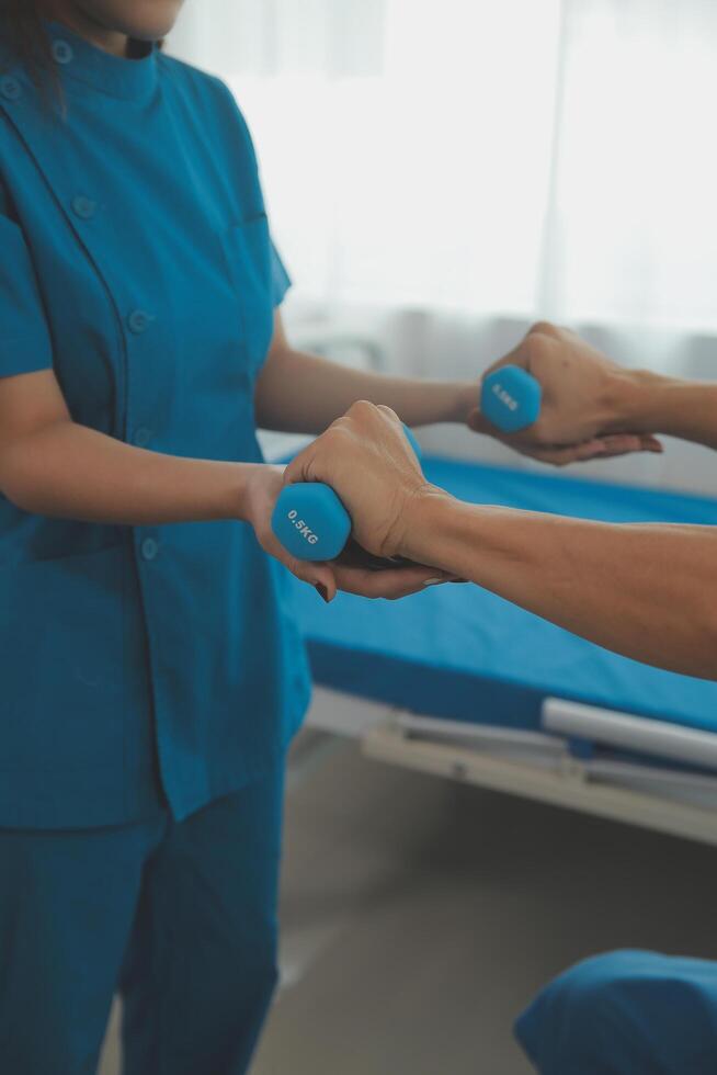 Physiotherapist man giving exercise with dumbbell treatment About Arm and Shoulder of athlete male patient Physical therapy concept photo