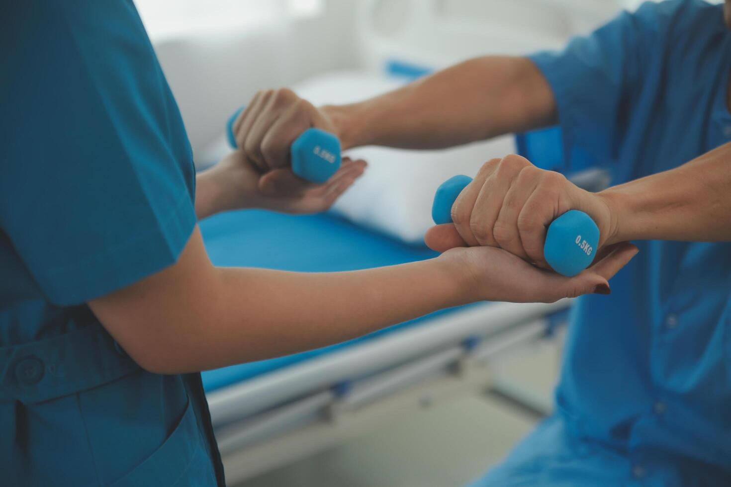 Physiotherapist man giving exercise with dumbbell treatment About Arm and Shoulder of athlete male patient Physical therapy concept photo