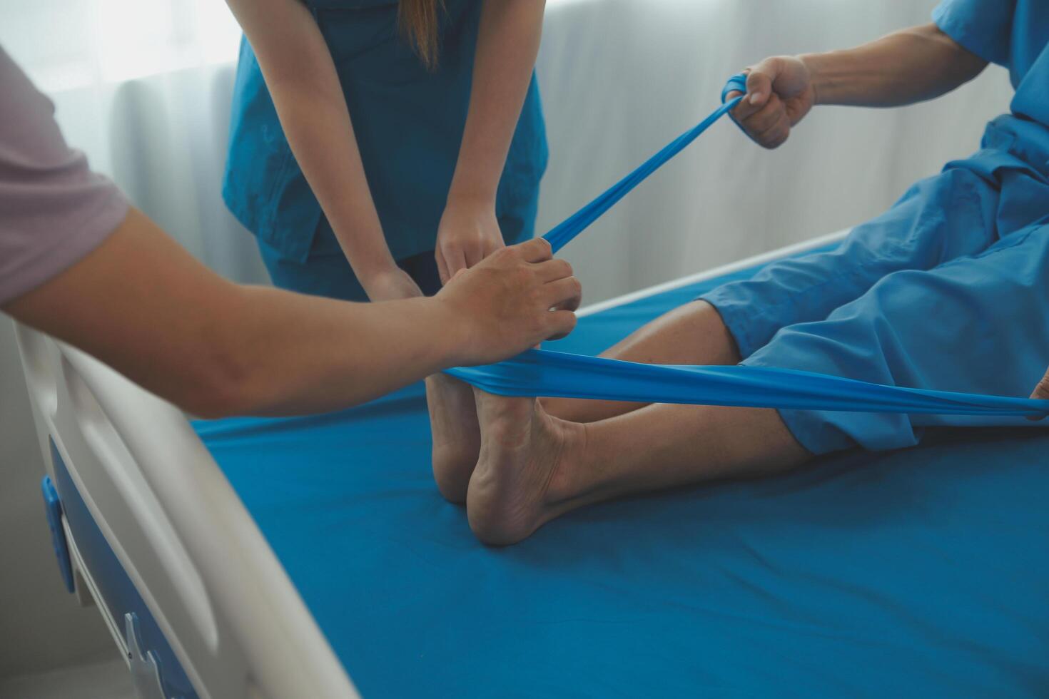 Professional orthopedist examining the little patient's leg in the clinic. Patient at the physiotherapy doing physical exercises with his therapist photo