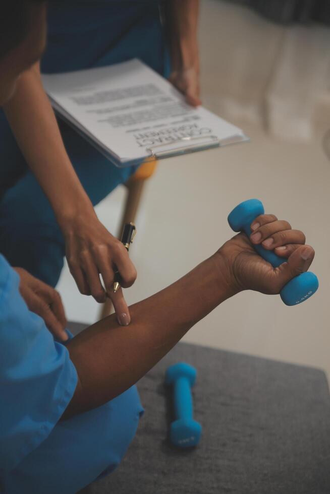 Professional physical therapist examines and cares for a young man in a physical therapy center, treating muscles and injuries of a man in a hospital. photo