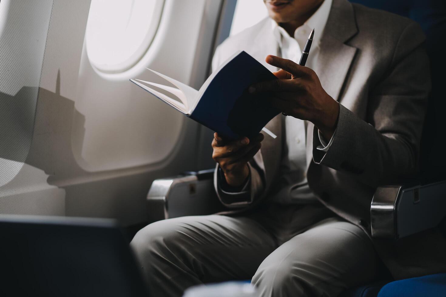 Airplane, travel and portrait of businessman working on laptop computer and smartphone while sitting in airplane. photo