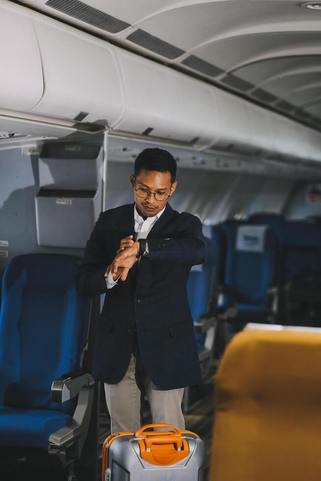 Going To Flight. Arab Businessman Walking With Suitcase In Airport And Looking At Wristwatch, Handsome Middle Eastern Male Traveller Checking Departure Time On Watch, Ready For Air Trip, Copy Space photo