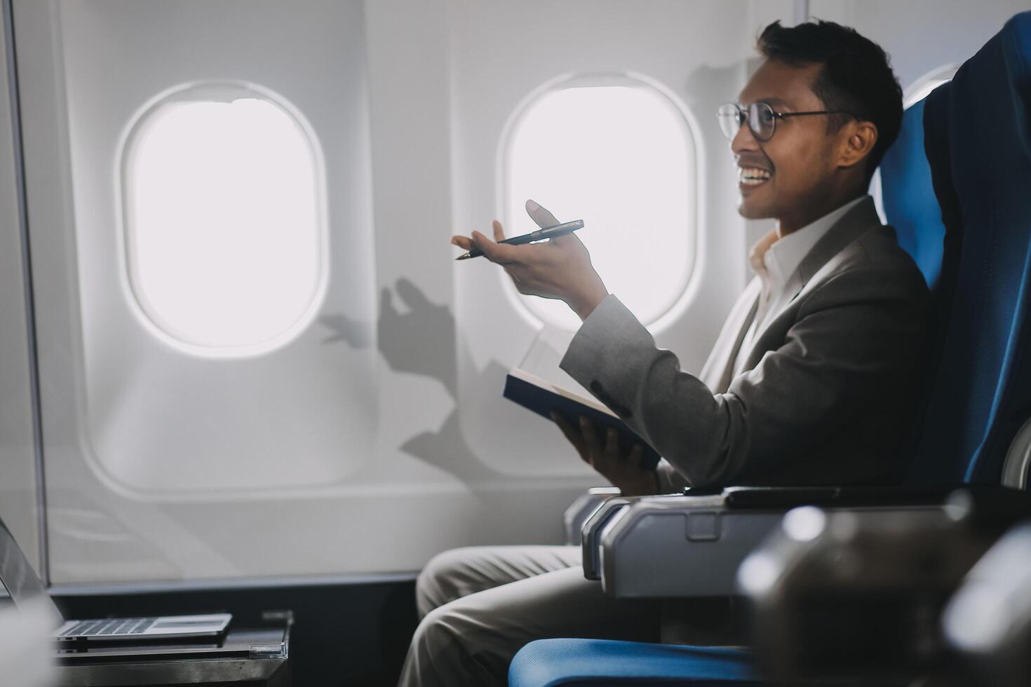 Airplane, travel and portrait of businessman working on laptop computer and smartphone while sitting in airplane. photo