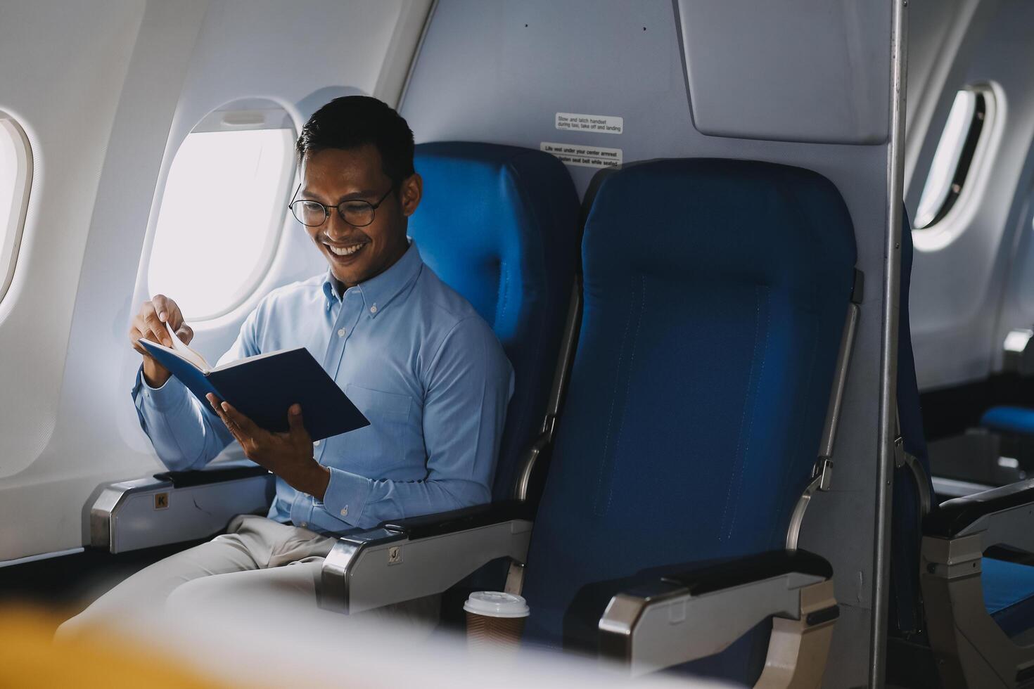 Airplane, travel and portrait of businessman working on laptop computer and smartphone while sitting in airplane. photo