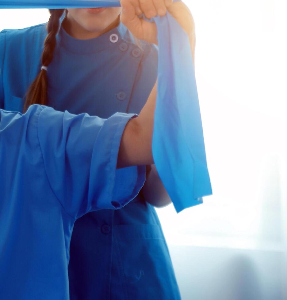 Close up hand patient doing stretching exercise with a flexible exercise band and a physical therapist hand to help in clinic room. photo