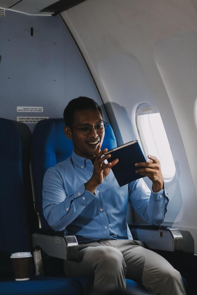 Airplane, travel and portrait of businessman working on laptop computer and smartphone while sitting in airplane. photo