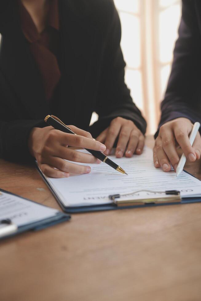 Lawyer, legal advisor, businessman brainstorming information on agreement details Business contracts in legal processing books for accuracy in contract documents. joint financial investment. photo