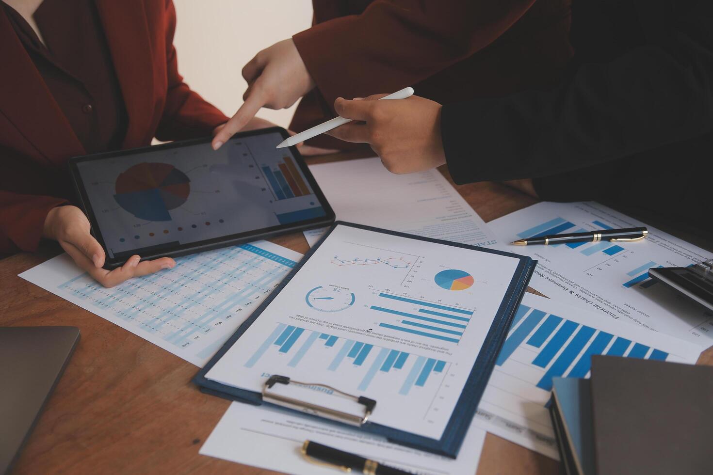 Group of confident business people point to graphs and charts to analyze market data, balance sheet, account, net profit to plan new sales strategies to increase production capacity. photo