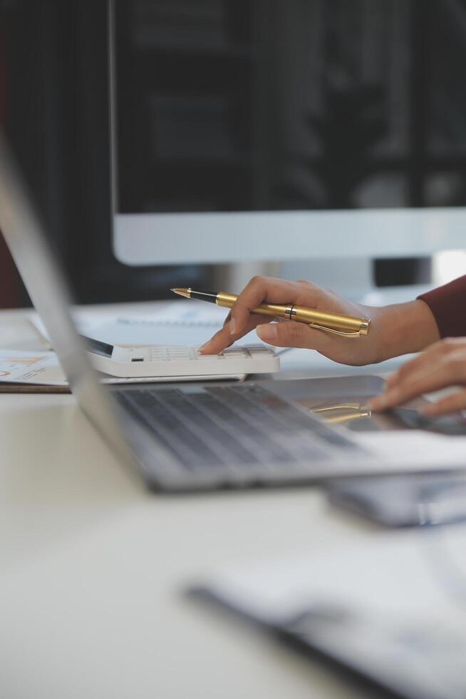 Cropped image of professional businesswoman working at her office via laptop, young female manager using portable computer device while sitting at modern loft, flare light, work process concept photo
