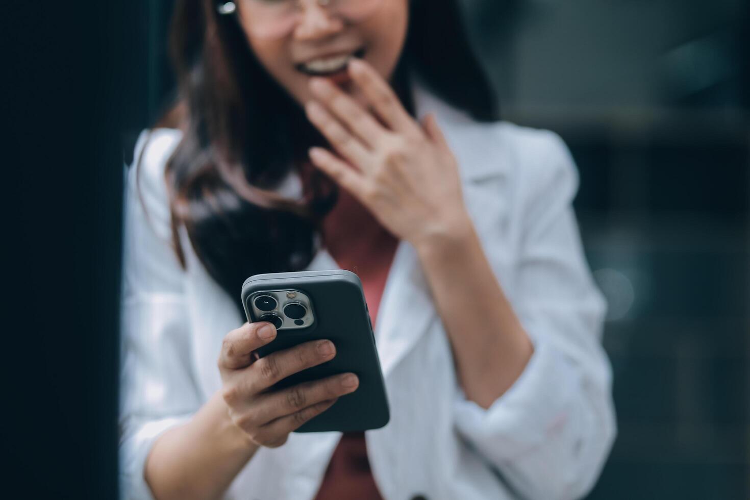 Portrait of a happy Asian businesswoman using mobile phone indoor, Asian businesswoman working in modern office. photo