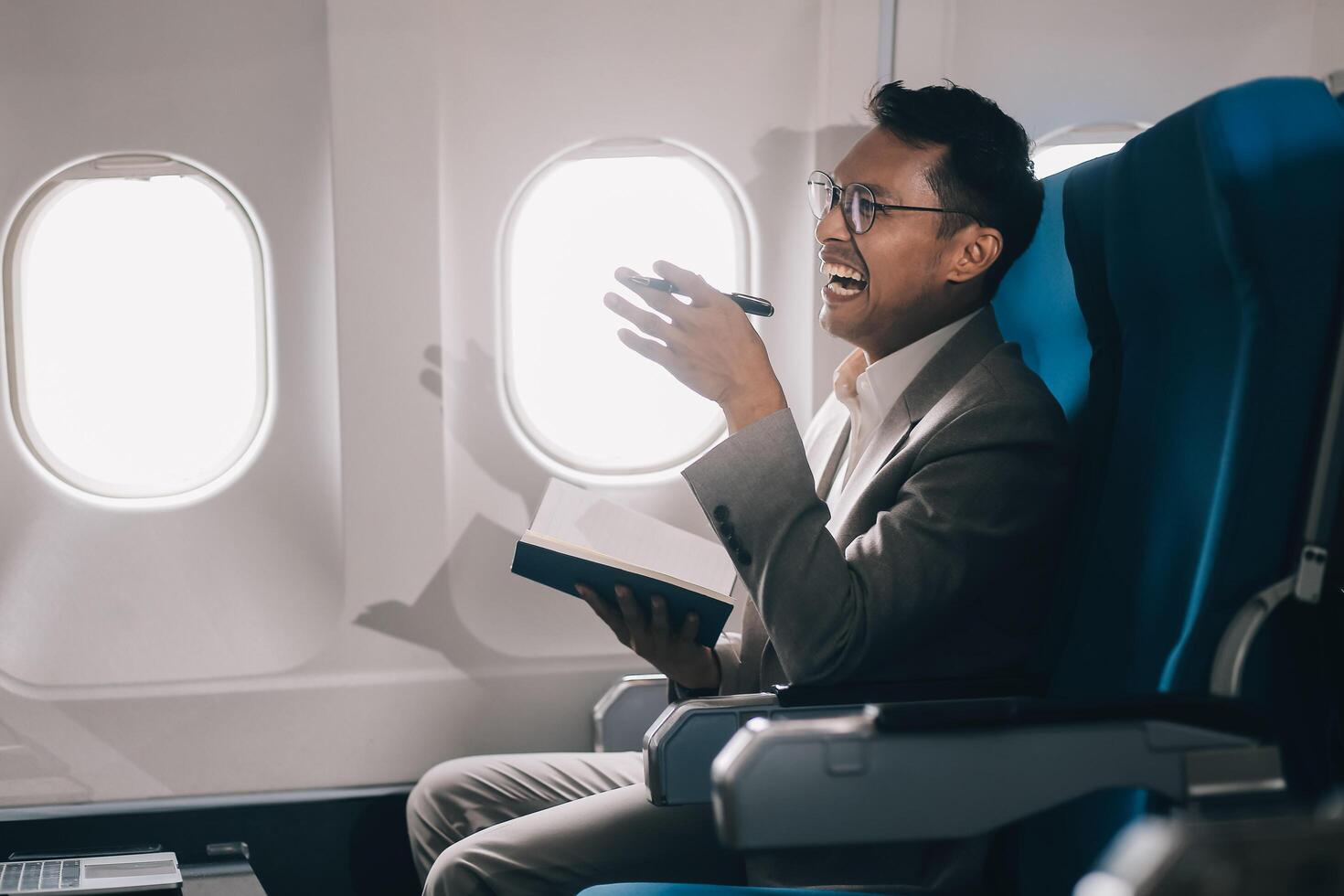 Airplane, travel and portrait of businessman working on laptop computer and smartphone while sitting in airplane. photo