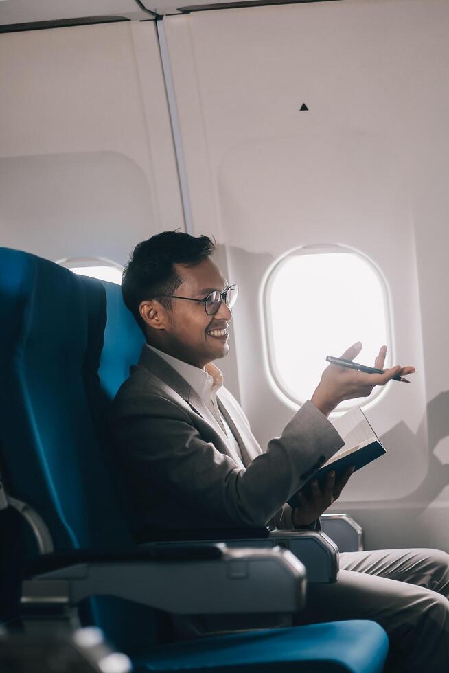 Airplane, travel and portrait of businessman working on laptop computer and smartphone while sitting in airplane. photo