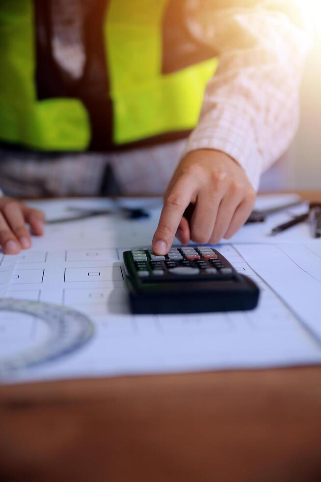 engineer people meeting working and pointing at a blueprint in office for discussing. Engineering tools and construction concept photo