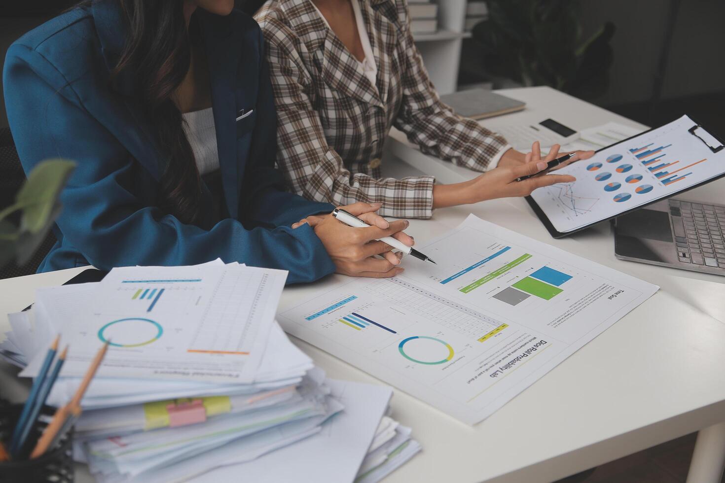 Group of confident business people point to graphs and charts to analyze market data, balance sheet, account, net profit to plan new sales strategies to increase production capacity. photo