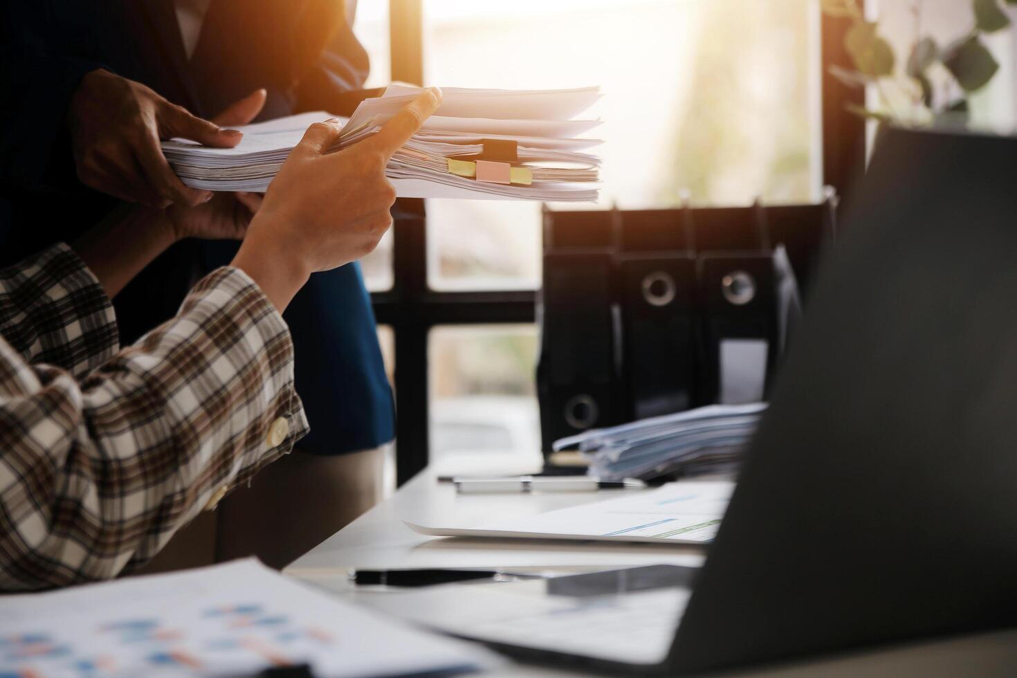 Group of confident business people point to graphs and charts to analyze market data, balance sheet, account, net profit to plan new sales strategies to increase production capacity. photo