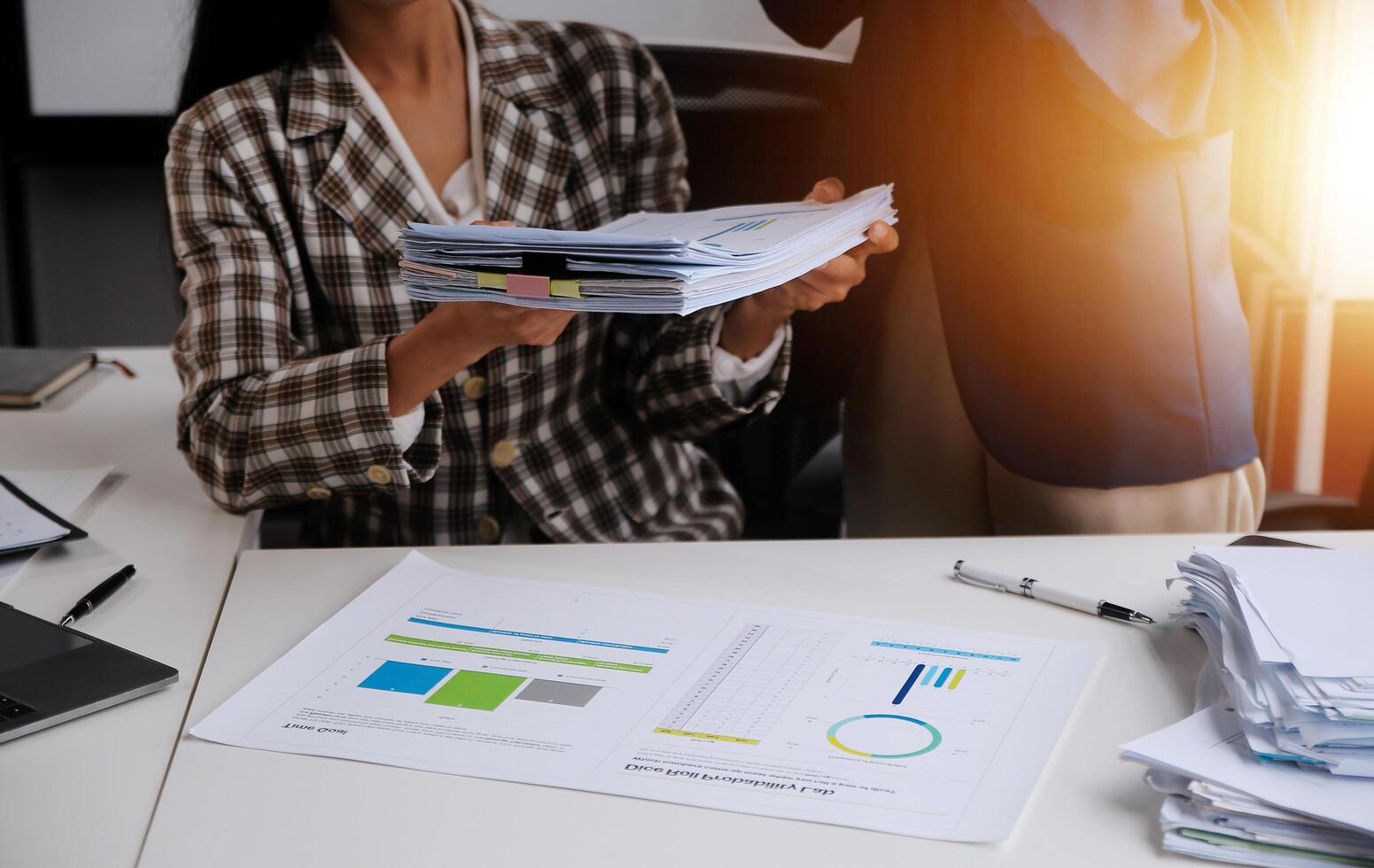 Group of confident business people point to graphs and charts to analyze market data, balance sheet, account, net profit to plan new sales strategies to increase production capacity. photo
