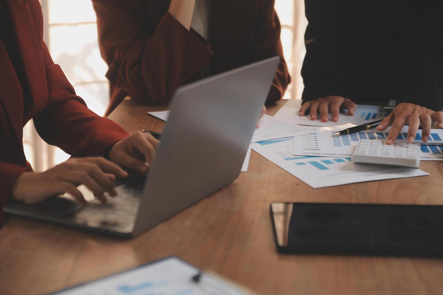 Group of confident business people point to graphs and charts to analyze market data, balance sheet, account, net profit to plan new sales strategies to increase production capacity. photo