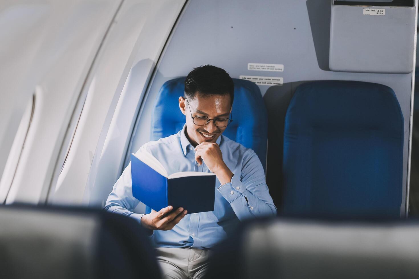 Airplane, travel and portrait of businessman working on laptop computer and smartphone while sitting in airplane. photo