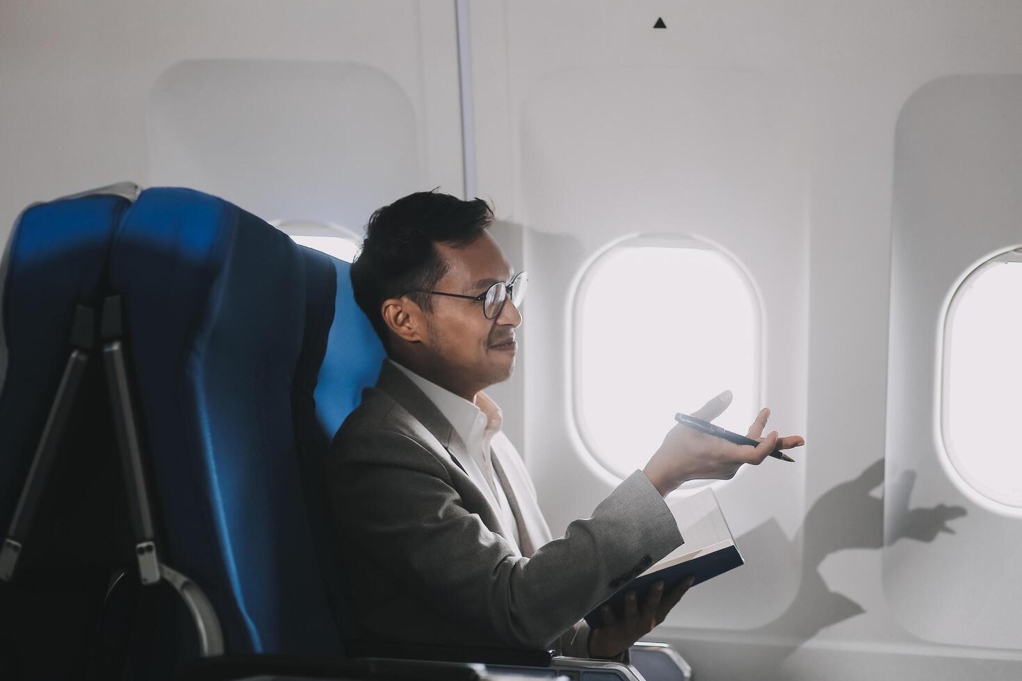 Airplane, travel and portrait of businessman working on laptop computer and smartphone while sitting in airplane. photo