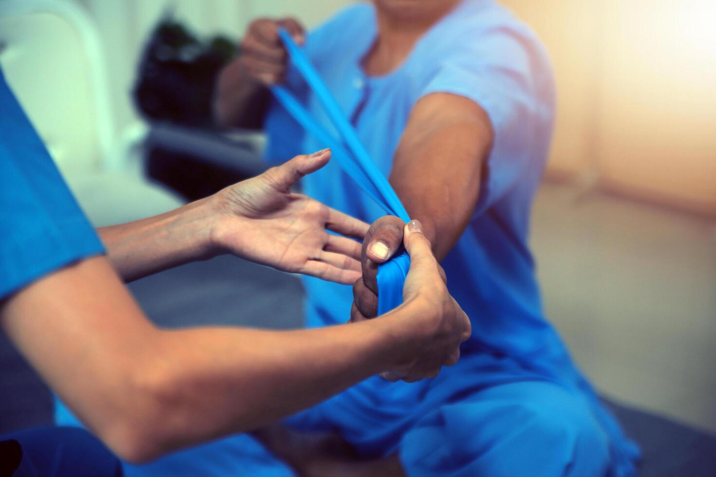 Professional physical therapist examines and cares for a young man in a physical therapy center, treating muscles and injuries of a man in a hospital. photo