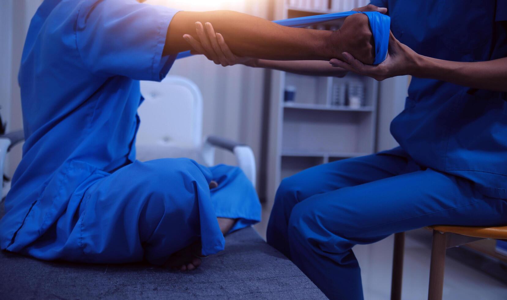 Professional physical therapist examines and cares for a young man in a physical therapy center, treating muscles and injuries of a man in a hospital. photo