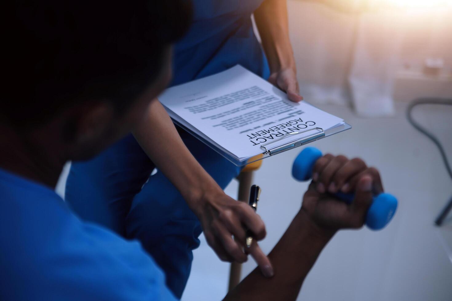 Professional physical therapist examines and cares for a young man in a physical therapy center, treating muscles and injuries of a man in a hospital. photo