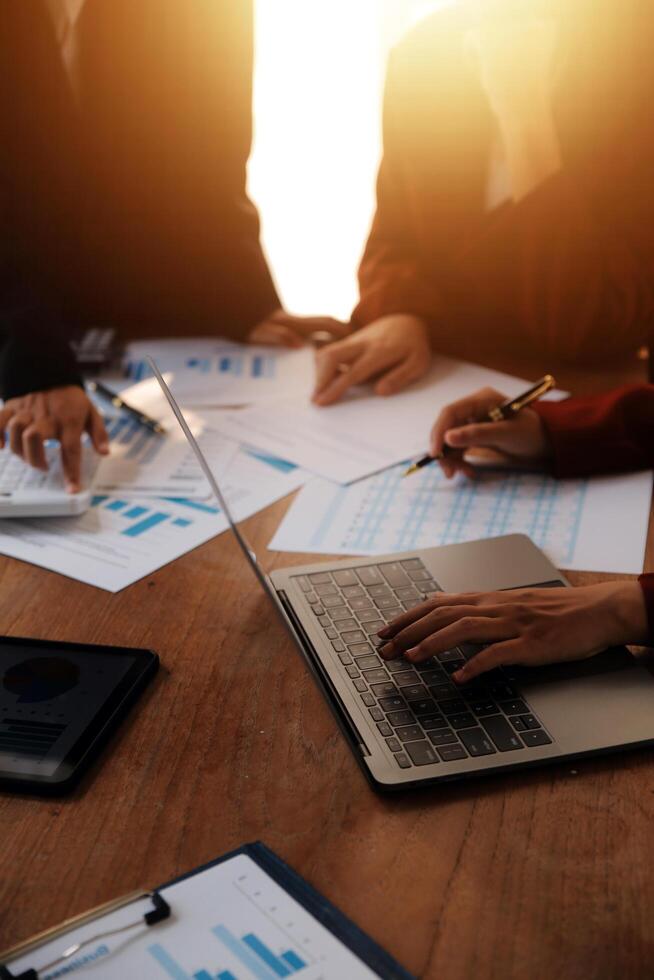 Group of confident business people point to graphs and charts to analyze market data, balance sheet, account, net profit to plan new sales strategies to increase production capacity. photo