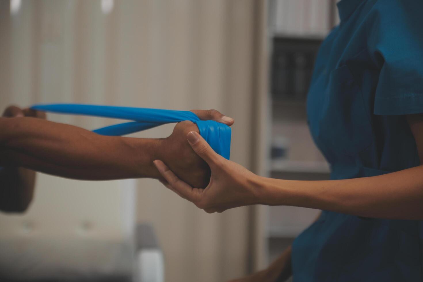 Professional physical therapist examines and cares for a young man in a physical therapy center, treating muscles and injuries of a man in a hospital. photo