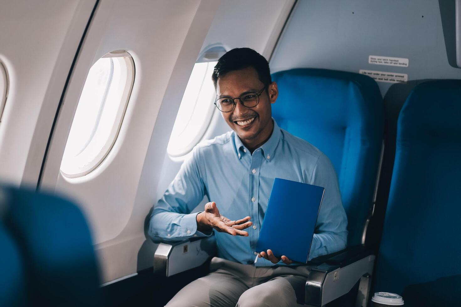 Airplane, travel and portrait of businessman working on laptop computer and smartphone while sitting in airplane. photo