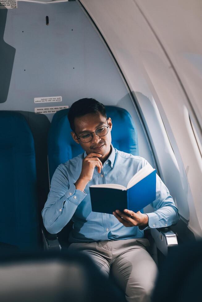 Airplane, travel and portrait of businessman working on laptop computer and smartphone while sitting in airplane. photo