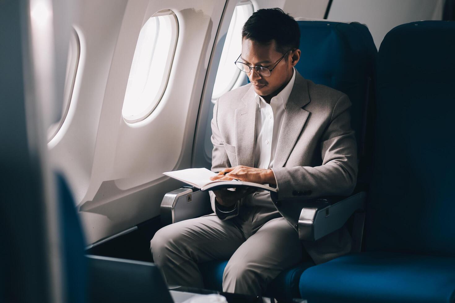 Airplane, travel and portrait of businessman working on laptop computer and smartphone while sitting in airplane. photo